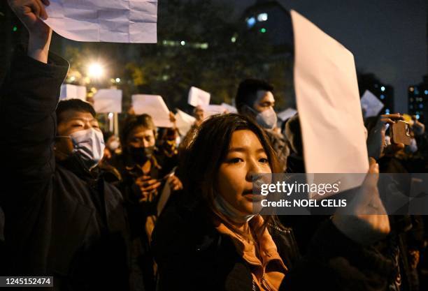 Protesters march along a street during a rally for the victims of a deadly fire as well as a protest against China's harsh Covid-19 restrictions in...