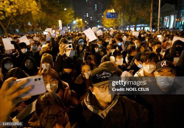 Protesters march along a street during a rally for the victims of a deadly fire as well as a protest against China's harsh Covid-19 restrictions in...