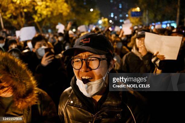 Protesters march along a street during a rally for the victims of a deadly fire as well as a protest against China's harsh Covid-19 restrictions in...