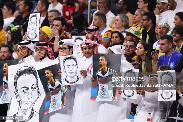 Local fans holding pictures and posters of Mesut Ozil during the FIFA World Cup Qatar 2022 Group E match between Spain and Germany at Al Bayt Stadium...