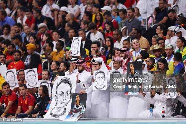 Local fans holding pictures and posters of Mesut Ozil during the FIFA World Cup Qatar 2022 Group E match between Spain and Germany at Al Bayt Stadium...