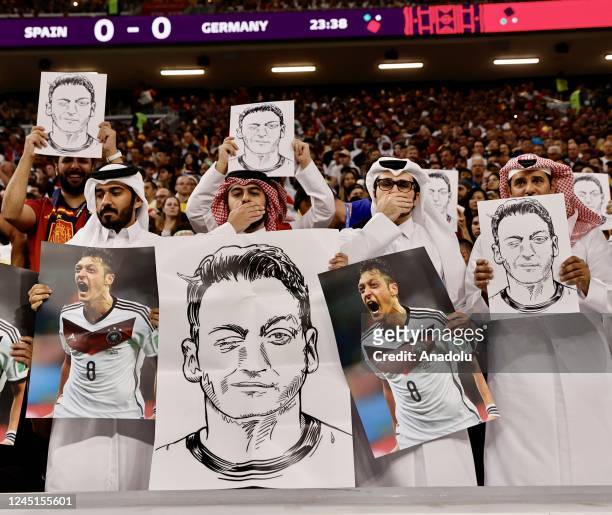 Fans hold photos and posters of Mesut Ozil of Medipol Basaksehir during the FIFA World Cup Qatar 2022 Group E match between Spain and Germany at Al...