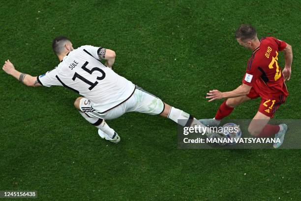 Germany's defender Niklas Suele and Spain's forward Dani Olmo fight for the ball during the Qatar 2022 World Cup Group E football match between Spain...