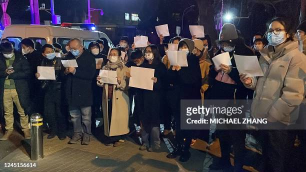 Protesters gather along a street during a rally for the victims of a deadly fire as well as a protest against China's harsh Covid-19 restrictions in...