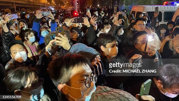 Protesters gather along a street during a rally for the victims of a deadly fire as well as a protest against China's harsh Covid-19 restrictions in...