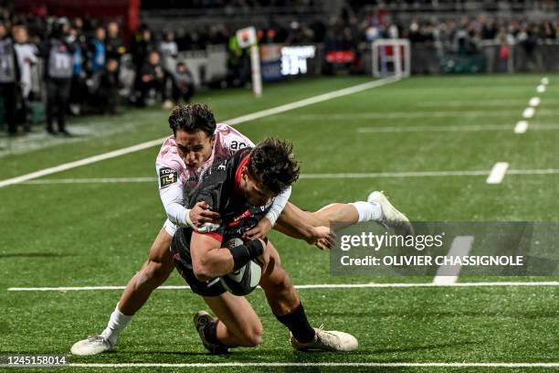 Lyon's French centre Ethan Dumortier scores a try despite Toulouse's Italian fullback Ange Capuozzo during the French Top 14 rugby union match...