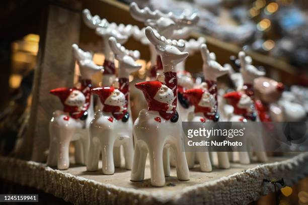 View of a stall with Christmas decorations on display at a crowded Christmas Market on the Main Market Square in Krakow. On Sunday, November 27 in...