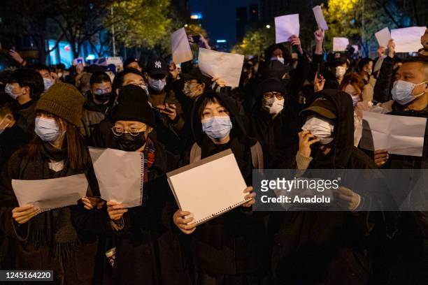 Demonstrators hold white signs as a form of protest during a protest against Zero Covid and epidemic prevention restrictions in Beijing, China, on...