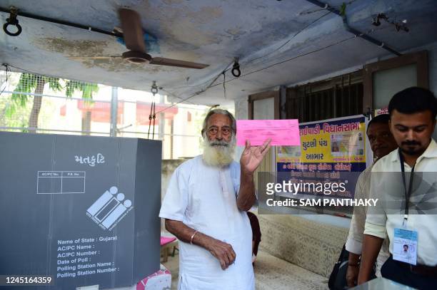Senior citizen casts his vote on postal ballots in the presence of Election Commission officials at his house in Ahmedabad on November 28 ahead of...