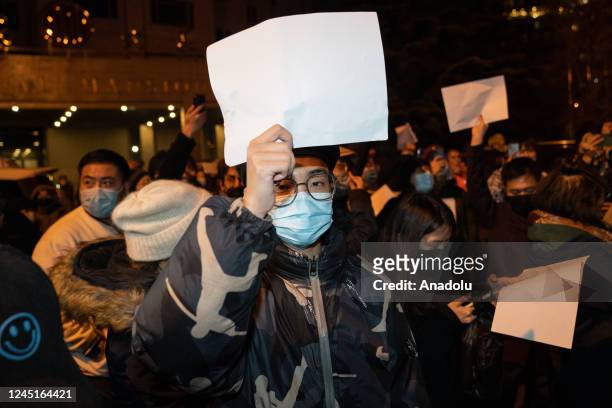 Demonstrators hold white signs as a form of protest during a protest against Zero Covid and epidemic prevention restrictions in Beijing, China, on...