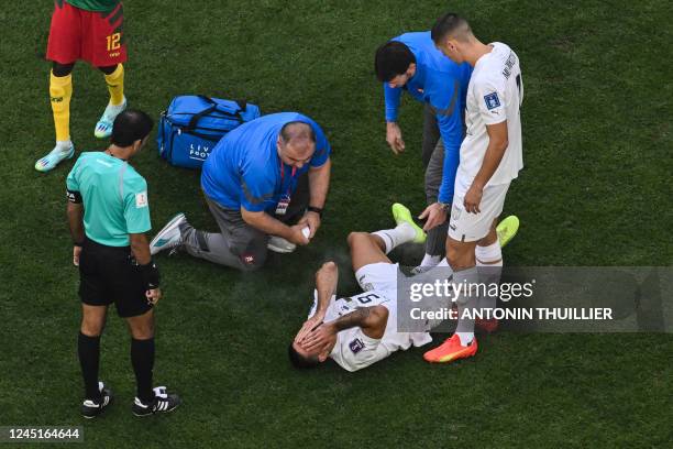 Serbia's forward Aleksandar Mitrovic receives medical attention during the Qatar 2022 World Cup Group G football match between Cameroon and Serbia at...