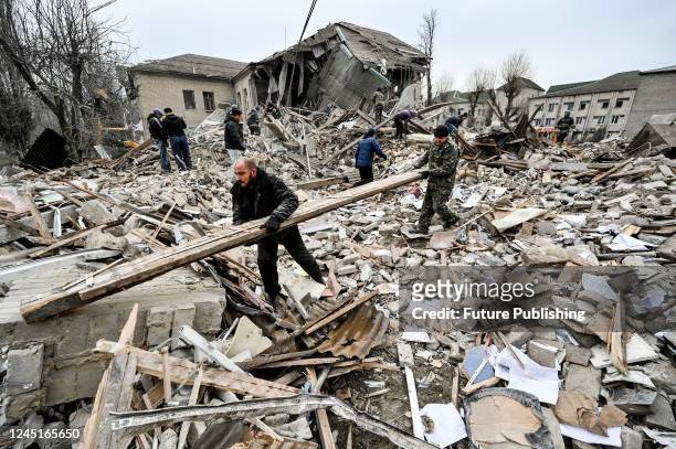 Men help State Emergency Service rescuers remove the rubble at the maternity ward of the Vilniansk Multidisciplinary Hospital destroyed in a missile...