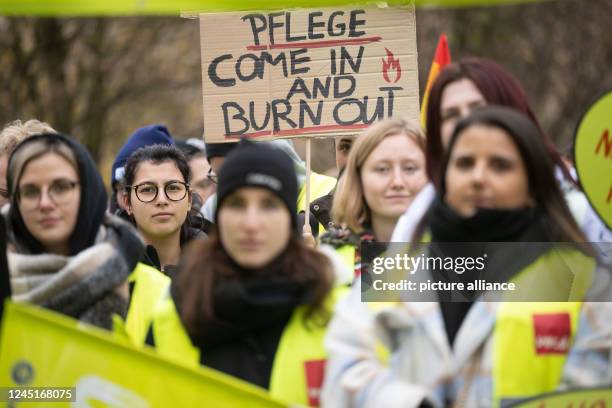 November 2022, Baden-Wuerttemberg, Tübingen: Participants of a rally at the University Hospital of Tübingen stand in front of a poster with the...