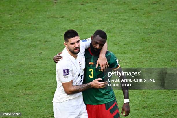 Cameroon's defender Nicolas Nkoulou hugs Serbia's forward Aleksandar Mitrovic at the end of the Qatar 2022 World Cup Group G football match between...