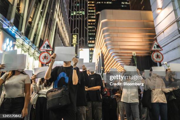 Demonstrators hold blank protest signs during a vigil commemorating victims of China's Covid Zero policy in Hong Kong, China, on Monday, Nov. 28,...