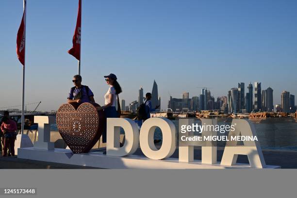 Tourists pose for photos at the Corniche promenade in Doha on November 28, 2022 during the Qatar 2022 World Cup football tournament.