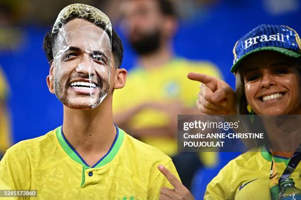 Brazil supporter wearing a mask of Brazil's forward Neymar waits for the start of the Qatar 2022 World Cup Group G football match between Brazil and...