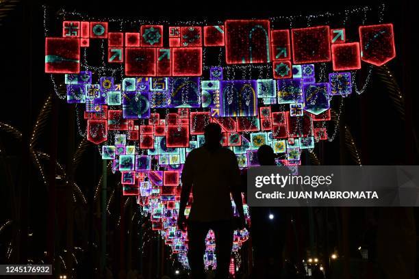 People seen in silhouette under street illuminations on the Corniche promenade in Doha, on November 28 during Qatar 2022 World Cup football...