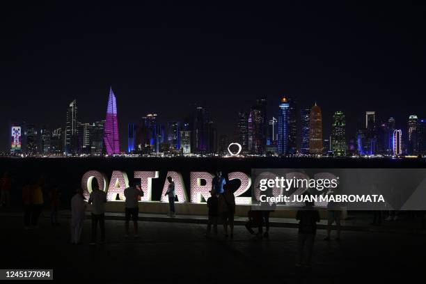 People walk along the Corniche promenade as skyscrapers of the West Bay are seen in the background in Doha, on November 28 during Qatar 2022 World...