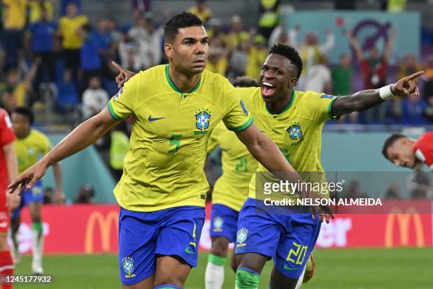 Brazil's midfielder Casemiro celebrates with Brazil's forward Vinicius Junior after he scored his team's first goal during the Qatar 2022 World Cup...