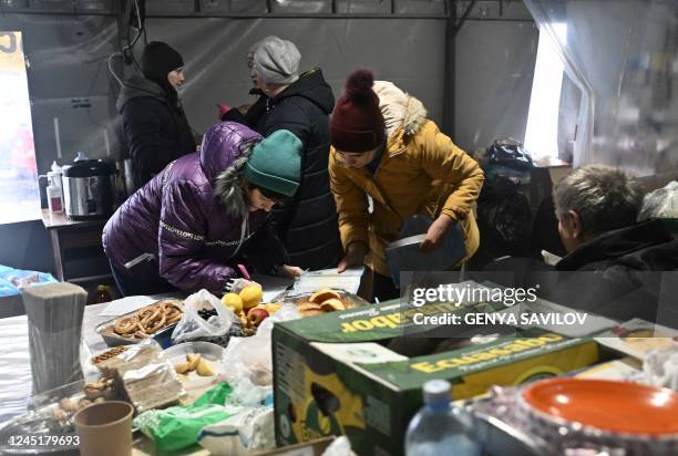 Local residents visit a tent where they can warm themselves, get hot drinks, charge their devices in town of Vyshgorod, outside of Kyiv on November...