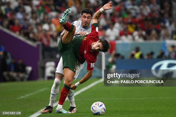 Uruguay's defender Jose Maria Gimenez and Portugal's forward Joao Felix fight for the ball during the Qatar 2022 World Cup Group H football match...