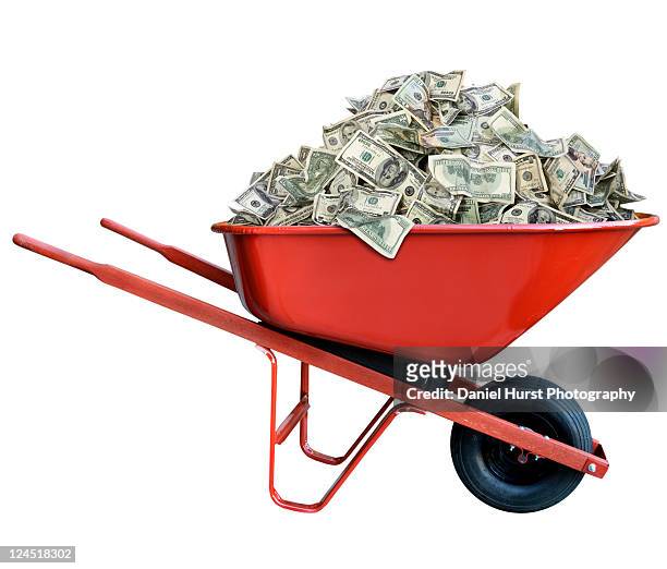 pile of money in wheel barrow - money in wheelbarrow stockfoto's en -beelden