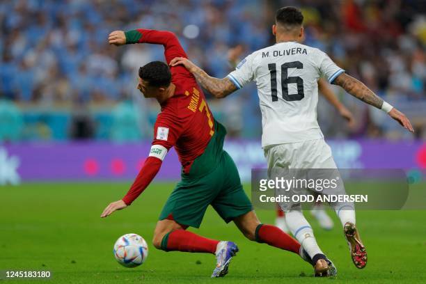 Portugal's forward Cristiano Ronaldo and Uruguay's defender Mathias Olivera fight for the ball during the Qatar 2022 World Cup Group H football match...