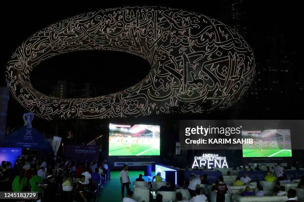 Fans watch a live broadcast of the Qatar 2022 World Cup Group football match between Brazil and Switzerland, near the museum of the Future in Dubai,...