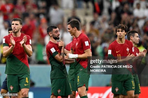 Portugal's midfielder Bruno Fernandes celebrates with Portugal's midfielder Joao Palhinha after they won the Qatar 2022 World Cup Group H football...