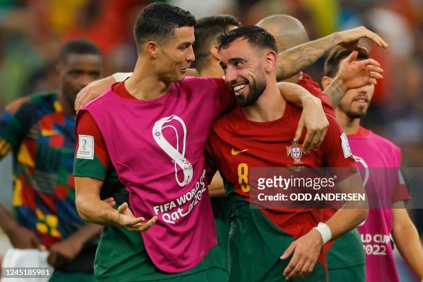Portugal's forward Cristiano Ronaldo and Portugal's midfielder Bruno Fernandes celebrate after they won the Qatar 2022 World Cup Group H football...