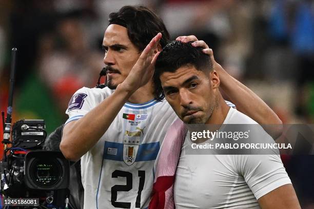 Uruguay's forward Edinson Cavani and Uruguay's forward Luis Suarez look dejected after they lost the Qatar 2022 World Cup Group H football match...