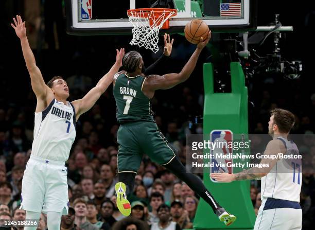 November 23: Jaylen Brown of the Boston Celtics puts two points up in-between Dwight Powell and Luka Doncic of the Dallas Mavericks during the first...