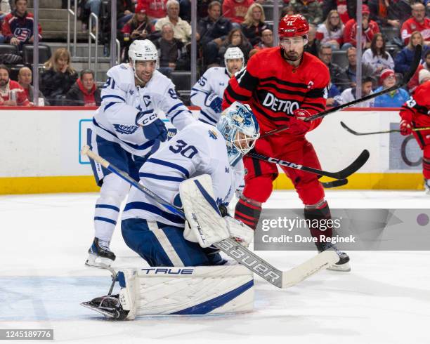 Matt Murray of the Toronto Maple Leafs makes a save as Dylan Larkin of the Detroit Red Wings looks for a rebound during third period of an NHL game...