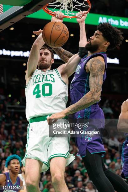 Luke Kornet of the Boston Celtics dunks the ball over Nick Richards of the Charlotte Hornets during a game at TD Garden on November 28, 2022 in...