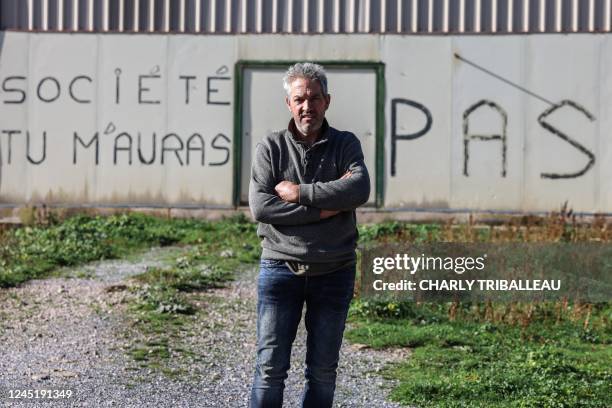 Christian Cros poses in front of his farm where he keep his 380 ewes to produce milk for the manufacture of Roquefort cheese, as the message "Society...
