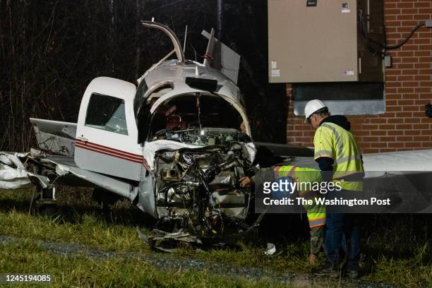 Pepco crews inspect a plane after crashed into a transmission line yesterday, cutting power to over 100,000 homes in the surrounding area in...