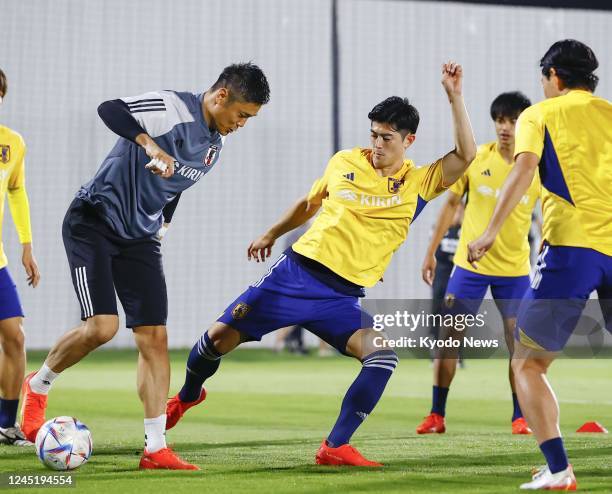 Japan goalkeeper Eiji Kawashima and defender Shogo Taniguchi train with the squad for their next World Cup Group E football match against Spain in...