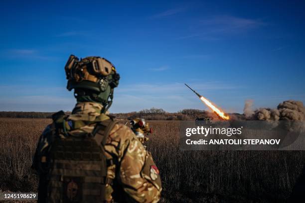 Ukrainian soldier watches a self-propelled 220 mm multiple rocket launcher "Bureviy" firing towards Russian positions on the front line, eastern...