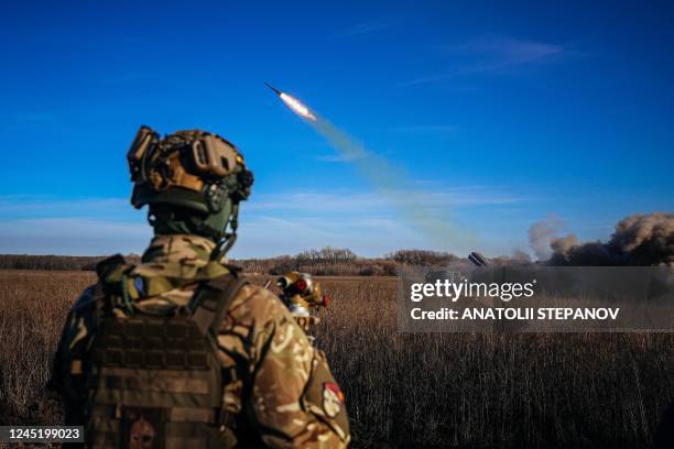 Ukrainian soldier watches a self-propelled 220 mm multiple rocket launcher "Bureviy" firing towards Russian positions on the front line, eastern...