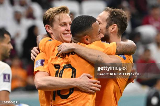 Netherlands' midfielder Frenkie De Jong celebrates scoring his team's second goal with his teammates Netherlands' forward Memphis Depay and...
