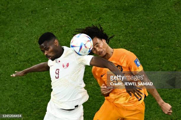 Qatar's forward Mohammed Muntari fights for the ball with Netherlands' defender Nathan Ake during the Qatar 2022 World Cup Group A football match...
