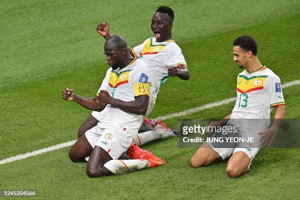 Senegal's defender Kalidou Koulibaly celebrates with teammates Senegal's midfielder Pape Gueye and Senegal's forward Iliman Ndiaye after scoring his...
