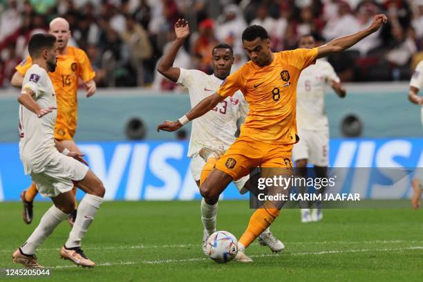 Netherlands' forward Cody Gakpo scores the opening goal during the Qatar 2022 World Cup Group A football match between the Netherlands and Qatar at...