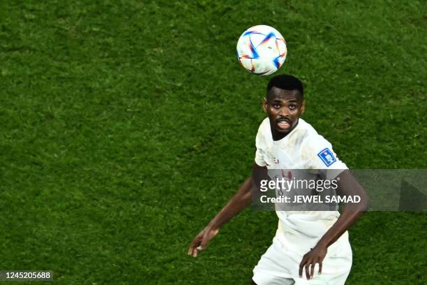 Qatar's forward Mohammed Muntari looks at the ball during the Qatar 2022 World Cup Group A football match between the Netherlands and Qatar at the...