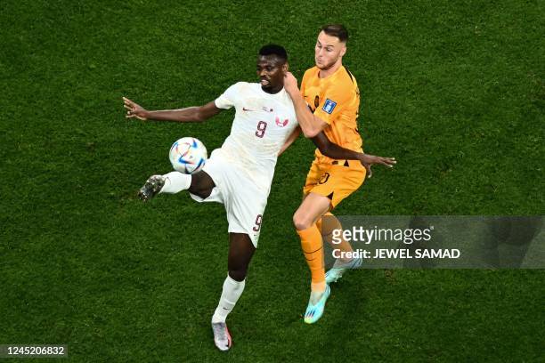 Qatar's forward Mohammed Muntari fights for the ball with Netherlands' midfielder Teun Koopmeiners during the Qatar 2022 World Cup Group A football...