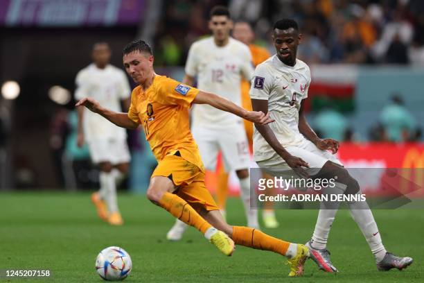 Netherlands' midfielder Steven Berghuis fights for the ball with Qatar's forward Mohammed Muntari during the Qatar 2022 World Cup Group A football...