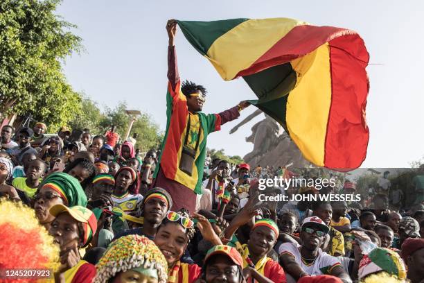 Senegalese fan waves the national flag as he watches a live broadcast of the Qatar 2022 World Cup Group A football match between Ecuador and Senegal...