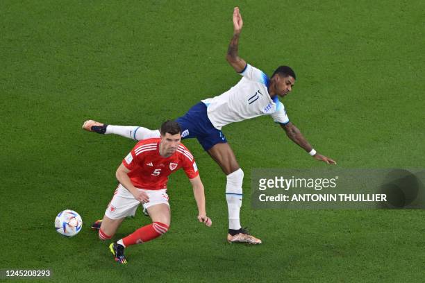England's forward Marcus Rashford fights for the ball with Wales' defender Chris Mepham during the Qatar 2022 World Cup Group B football match...