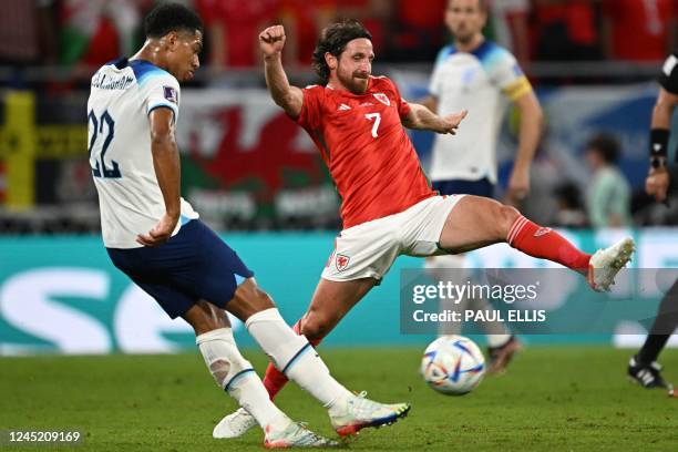 Wales' midfielder Joe Allen tries to block England's midfielder Jude Bellingham during the Qatar 2022 World Cup Group B football match between Wales...